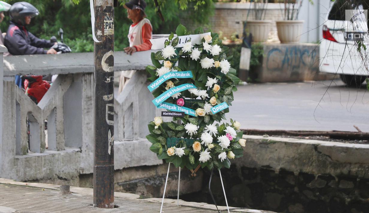 Karangan bunga berdiri di tiang lampu lokasi kecelakaan Setya Novanto di Jalan Permata Berlian, Jakarta, Sabtu (18/11). Pada karangan itu tertulis pesan "Walau Sudah Ditabrak Semoga Hukum Kita Setegak Tiang Ini #GetWellSoon." (Liputan6.com/Angga Yuniar)