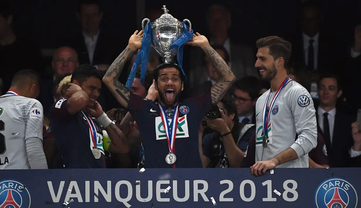Bek Paris Saint-Germain, Daniel Alves berpose dengan trofi seusai menjuarai Piala Prancis (Coupe de France) di Stade de France, Rabu (9/5). PSG menang 2-0 atas Tim divisi tiga, Les Herbiers pada final Piala Prancis. (AFP/FRANCK FIFE)