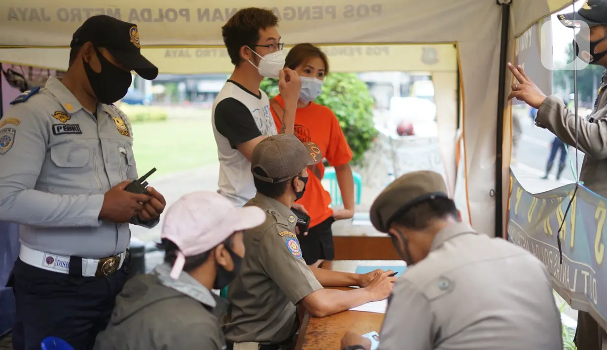 Petugas gabungan mendata warga yang terjaring Operasi Yustisi Protokol Covid-19 di kawasan Tugu Tani, Jakarta, Senin (14/9/2020). Operasi tersebut digelar sebagai langkah untuk menekan penyebaran Covid-19 di masa PSBB Jakarta. (Liputa6.com/Immanuel Antonius)