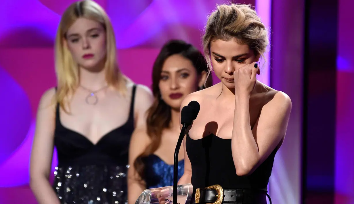 Penyanyi Selena Gomez menyeka air mata usai menerima penghargaan  Woman of the Year di atas panggung di Billboard Women In Music 2017 di Ballroom Ray Dolby di Hollywood & Highland Center di Hollywood, California (30/11). (AP/Chris Pizzello)