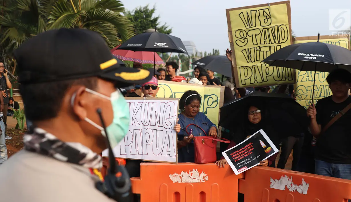 Peserta Aksi Kamisan ke-598 saat berunjuk rasa di depan Istana Merdeka, Jakarta, Kamis (22/8/2019). Aksi Kamisan ke-598 mengangkat permasalahan dan meminta pemerintah menghentikan kasus Rasisme, Kekerasan dan Diskriminasi yang terjadi di Papua. (Liputan6.com/Helmi Fithriansyah)