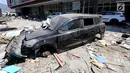 Sebuah mobil Datsun menjadi incaran jarahan korban gempa dan tsunami di Palu Grand Mal, Palu, Jumat (5/10). Warga korban gempa bumi mengambil ban dan interior mobil. (Liputan6.com/Fery Pradolo)