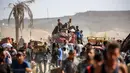 Orang-orang berjalan membawa paket bantuan kemanusiaan yang mereka terima dari pusat distribusi yang dikelola oleh Yayasan Kemanusiaan Gaza (GHF) yang didukung Amerika Serikat (AS) dan Israel, di koridor Netzarim, Nuseirat, Jalur Gaza tengah, pada 30 September 2025. (Eyad BABA/AFP)
