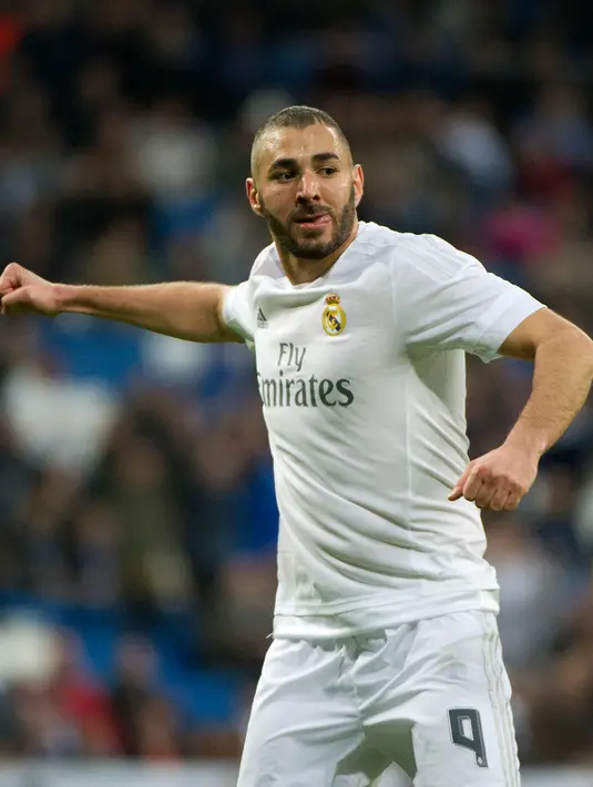 Penyerang Real Madrid, Karim Benzema melakukan selebrasi usai mencetak gol kegawang Rayo Vallecano pada lanjutan liga Spanyol di Santiago Bernabeu (20/12). Real Madrid menang telak atas Rayo Vallecano dengan skor 10-2. (AFP/curto DE LA TORRE)