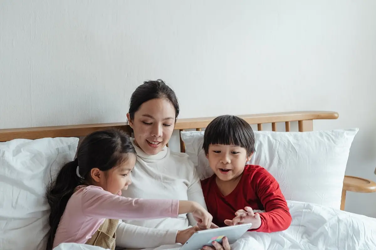 Ibu membacakan dongeng di kasur untuk anak (Pexels)