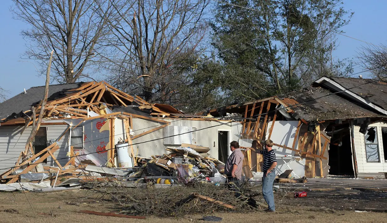 Alan Freeman dan Brandon Schmidt melihat kerusakan rumah mereka setelah tornado menghantam Clarksdale, Mississipi, Kamis (24/12). Badai tornado menerjang wilayah Amerika Serikat bagian selatan dan menewaskan 11 orang.  (REUTERS/ Justin A. Shaw)