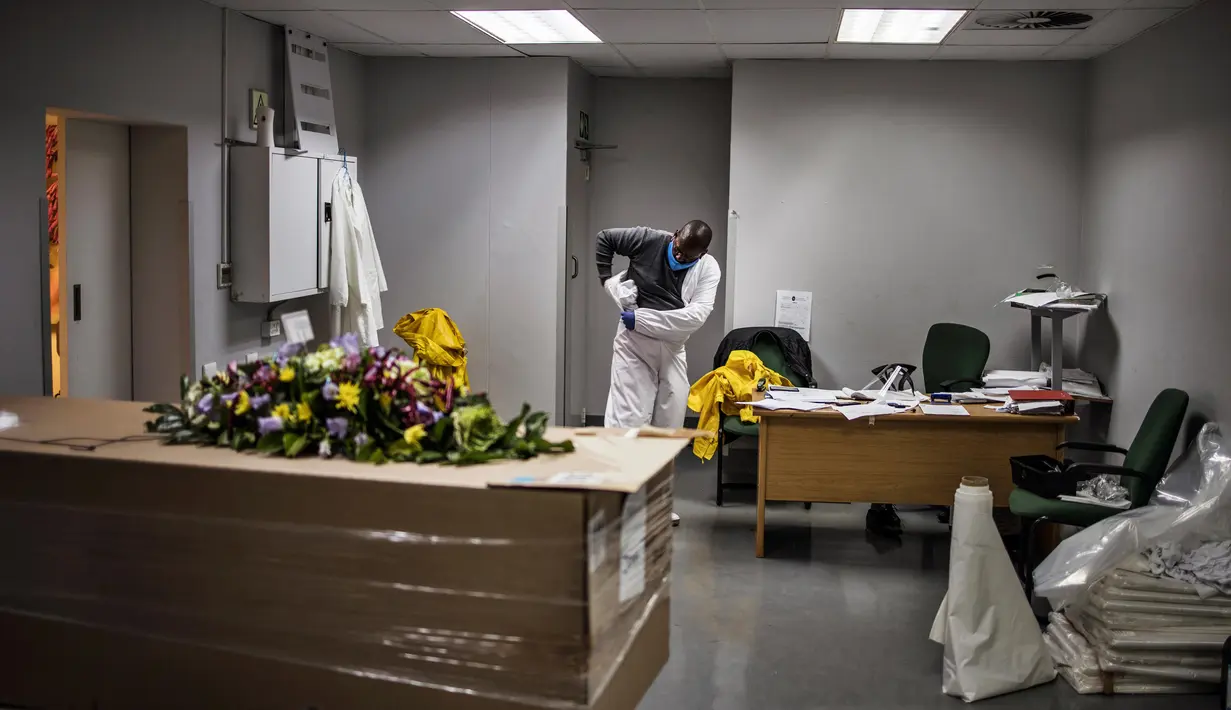 Seorang pengurus mengenakan alat pelindung diri (APD) di rumah duka AVBOB, Soweto, Afrika Selatan, 21 Juli 2020. (MARCO LONGARI/AFP)