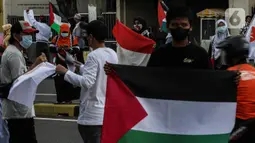 Masyarakat membawa bendera Palestina di jalan Basuki Rahmat, Jakarta, Kamis (20/5/2020). Aksi masyarakat tersebut untuk mengutuk penyerangan Israel ke Palestina yang telah menyebabkan ratusan korban jiwa. (Liputan6.com/Johan Tallo)