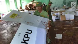 Petugas Linmas menyelamatkan kotak suara kardus yang sebagian rusak terendam banjir di gudang tempat penyimpanan logistik di Kecamatan Ciseeng, Bogor, Senin (15/4). Lebih dari 600 kotak suara rusak akibat tembok gudang jebol diterpa hujan lebat dan angin kencang semalam. (merdeka.com/Arie Basuki)