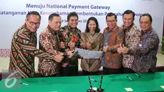 Menteri BUMN Rini Soemarno (tengah) bersama Gubernur BI Agus Martowardojo dan sejumlah Dirut Bank BUMN tengah memegang naskah MoU sinergi pembentukan perusahaan prinsipal di Jakarta, Jumat (9/9). (Liputan6.com/Angga Yuniar)