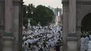 Para peserta dalam balutan serba putih  berkumpul untuk Dinner en Blanc atau "makan malam putih" di Tuileries Gardens, Paris, Kamis (6/6/2019). Mereka berkumpul untuk menggelar makan malam terbuka, yang berlangsung di tempat berbeda di Paris setiap tahun. (Lucas BARIOULET/AFP)