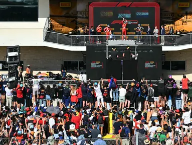 Penonton dan penggemar bersorak saat menyaksikan upacara podium kemenangan Grand Prix Formula 1 Amerika Serikat di Circuit of the Americas di Austin, Texas, pada 20 Oktober 2024. (ANGELA WEISS/AFP)