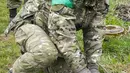 Seorang pencari ranjau dari Kementerian Dalam Negeri Ukraina menjinakkan sebuah ranjau di Irpin dekat Kiev, Ukraina, 19 April 2022. (AP Photo/Efrem Lukatsky)