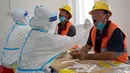 Staf medis mengambil sampel usap tenggorokan dari para pekerja konstruksi di lokasi pengambilan sampel sementara di Distrik Daxing, Beijing, China (2/7/2020). Sebanyak 1.353 pekerja di lokasi konstruksi tersebut menjalani pengambilan sampel tes asam nukleat pada Kamis (2/7). (Xinhua/Cai Yang)