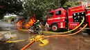 Pengemudi ojek online mendorong sepeda motor saat kebakaran melanda sebuah gudang di Jalan Kampung Bandan, Ancol, Jakarta Utara, Kamis (5/7). Kebakaran ini terjadi di dekat tempat wisata Kota Tua. (Kapanlagi.com/Budy Santoso)