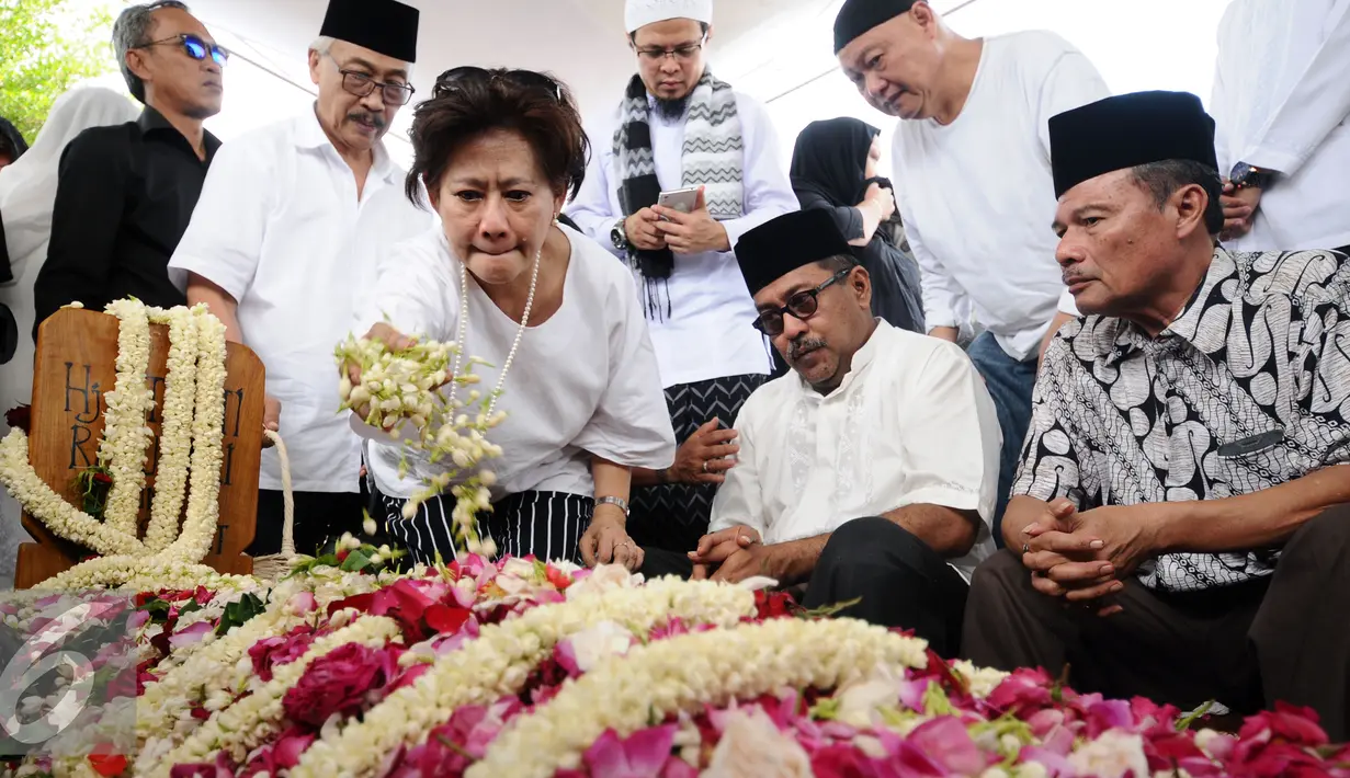 Gubernur Banten, Rano Karno (kedua kanan duduk) terduduk usai pemakaman ibunya, Lily Soekarno M Noor di TPU Tanah Kusir Jakarta, Senin (7/12/2015). Ibunda Rano Karno wafat di usia 77 tahun akibat komplikasi penyakit. (Liputan6.com/Helmi Fithriansyah)