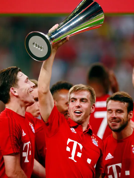 Bek Bayern Muenchen Philipp Lahm mengangkat piala Audi 2015 setelah timnya menang pada laga final  Audi Cup 2015, Allianz Arena , Munich , Jerman, Kamis (6/8/2015). Bayern Muenchen menang dengan skor 1-0. (Reuters/Jason Cairnduff)