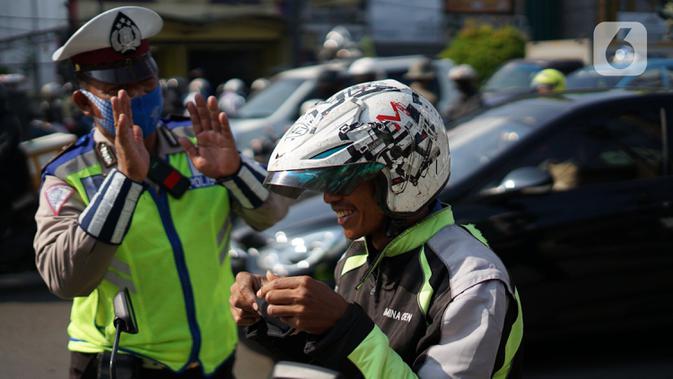 Polisi melakukan sosialisasi penggunaan masker kepada pengendara sepeda motor di kawasan Depok, Jawa Barat, Senin (20/7/2020). Setelah sosialisasi, Pemkot Depok akan menerapkan sanksi denda kepada warga yang melanggar. (Liputan6.com/Immanuel Antonius)