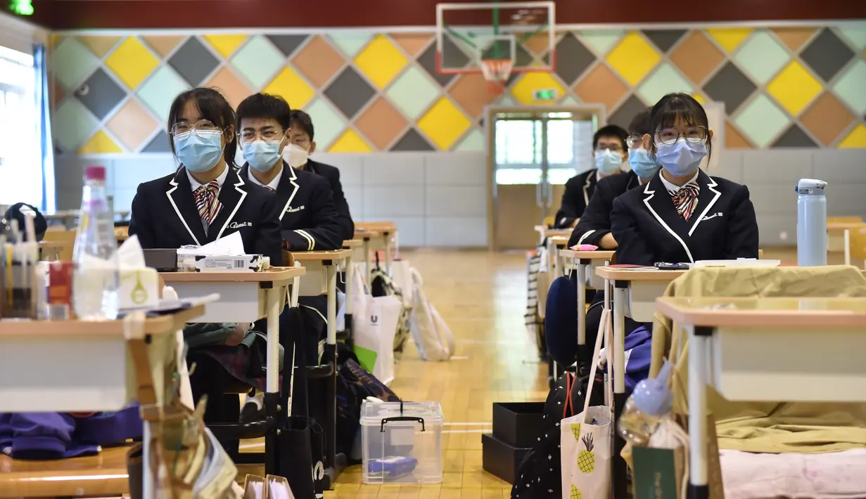 Sejumlah siswa di sebuah kelas dipindahkan ke gimnasium dalam ruangan untuk memastikan jarak aman antarkursi di Guangqumen Middle School, Beijing, China, Senin (27/4/2020). Sekolah menengah atas di Beijing memulai kembali kegiatan belajar di kelas untuk siswa tingkat akhir. (Xinhua/Chen Zhonghao)