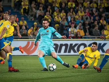 Gelandang Barcelona, Lionel Messi, berusaha melewati kepungan pemain Las Palmas pada laga La Liga Spanyol di Stadion Gran Canaria, Las Palmas, Kamis (1/3/2018). Kedua klub bermain imbang 1-1. (AFP/Desiree Martin)