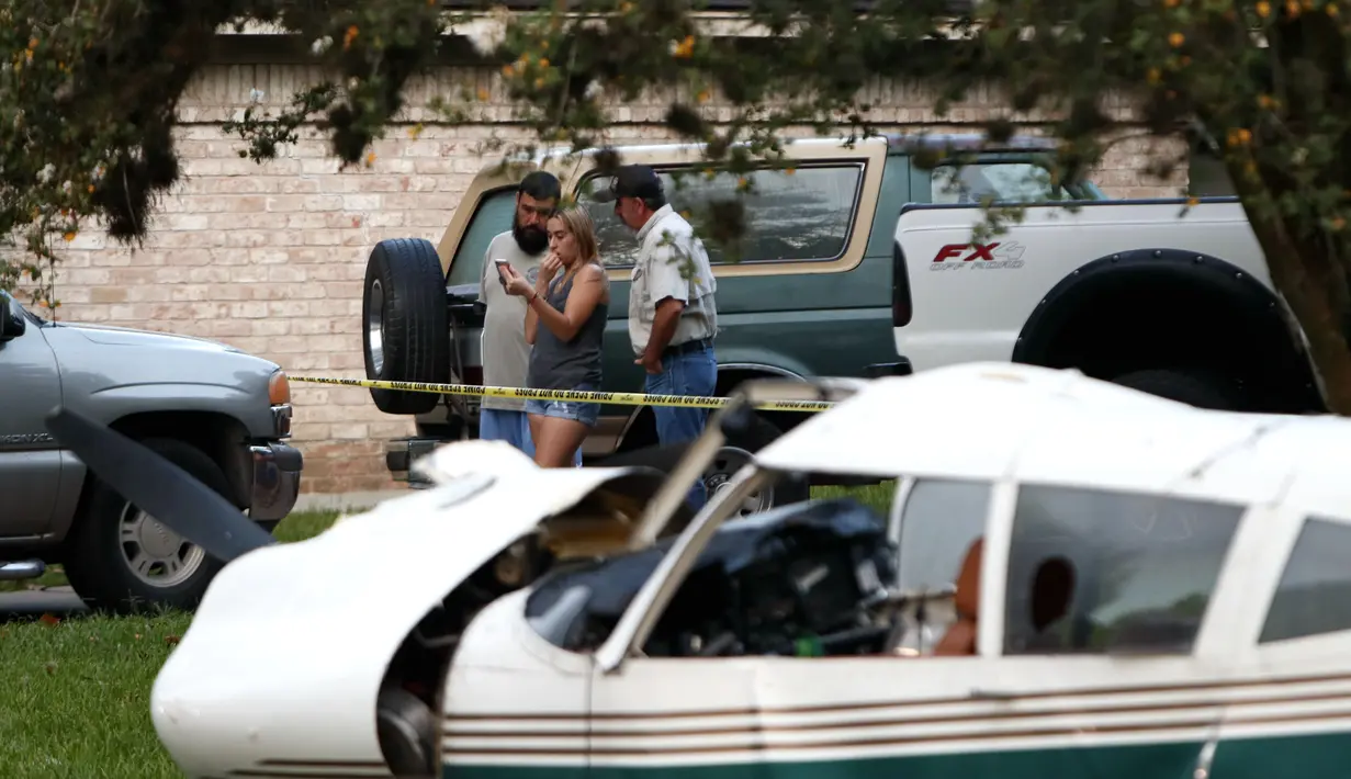 Sejumlah warga terlihat di lokasi kecelakaan pesawat di daerah Houston di Texas, Amerika Serikat (AS) (28/7/2020). Dua orang terluka ketika pesawat kecil itu jatuh pada Selasa (28/7) pagi di sebuah permukiman di Houston. (Xinhua/Steven Song)