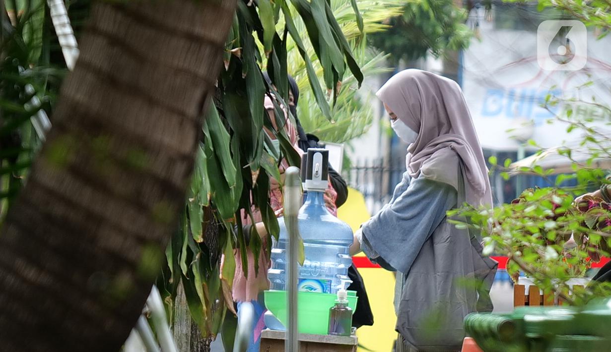 Pengunjung mencuci tangan sebelum memasuki M Bloc Space di Jakarta, Sabtu (11/7/2020). Sempat tutup sementara hampir tiga bulan, tempat nongkrong hits beragam kalangan di bekas kompleks Peruri ini mulai beroperasi kembali pukul 12.00-20.00 WIB. (Liputan6.com/Herman Zakharia)