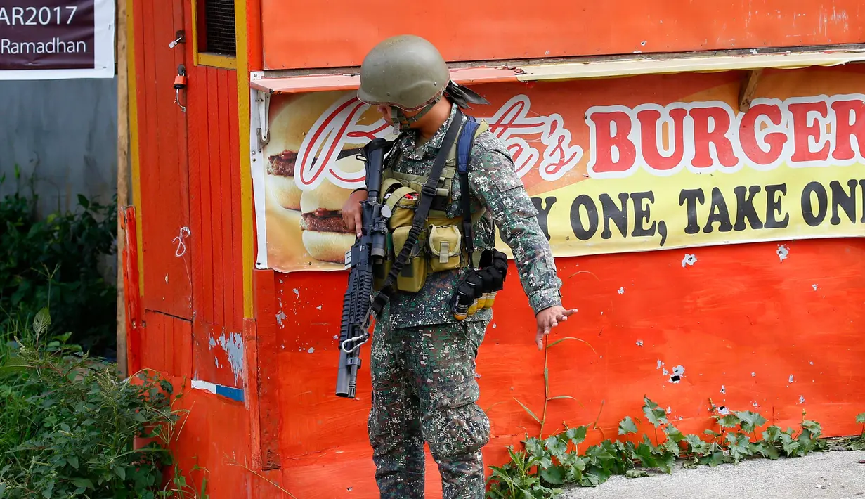 Tentara Filipina memberi intruksi kepada anak buahnya saat bertempur melawan militan maute di kota Marawi, Filipina Selatan (28/5). Sejumlah warga mengibarkan bendera putih agar mereka tidak diserang oleh pasukan pemerintah. (AP Photo/Bullit Marquez)