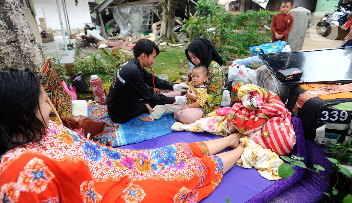 Tenaga medis dari Dinas Kesehatan Kabupaten Karawang melakukan pemeriksaan kesehatan seorang anak pengungsi korban gempa bumi di desa Mangunkerta, kecamatan Cugenang, Cianjur, Jawa Barat, Rabu (23/11/2022). Hari ketiga pasca gempa magnitudo 5,6 mengguncang Cianjur, sejumlah bantuan dari berbagai kota di Pulau Jawa mulai berdatangan.
(merdeka.com/Arie Basuki)