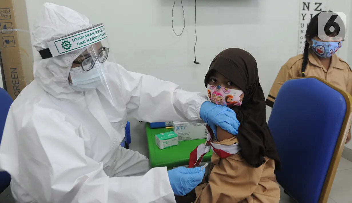 Dokter memberikan imunisasi campak kepada murid baru sekolah dasar negeri di Puskesmas Pondok Labu, Jakarta Selatan, Rabu (12/8/2020). Selain dalam rangka Bulan Imunisasi Anak Sekolah, kegiatan ini juga bagian dari pemeriksaan kesehatan murid baru sekolah dasar negeri. (merdeka.com/Arie Basuki)