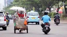 Tuna wisma menarik gerobaknya saat melintas di Jalan Margonda Raya, Depok, Kamis (16/4/2020). Pandemi COVID-19 memberikan dampak yang sangat besar bagi sosial dan ekonomi Indonesia. Bahkan yang paling dikhawatirkan bertambahnya angka kemiskinan dan pengangguran. (Liputan6.com/Helmi Fithriansyah)