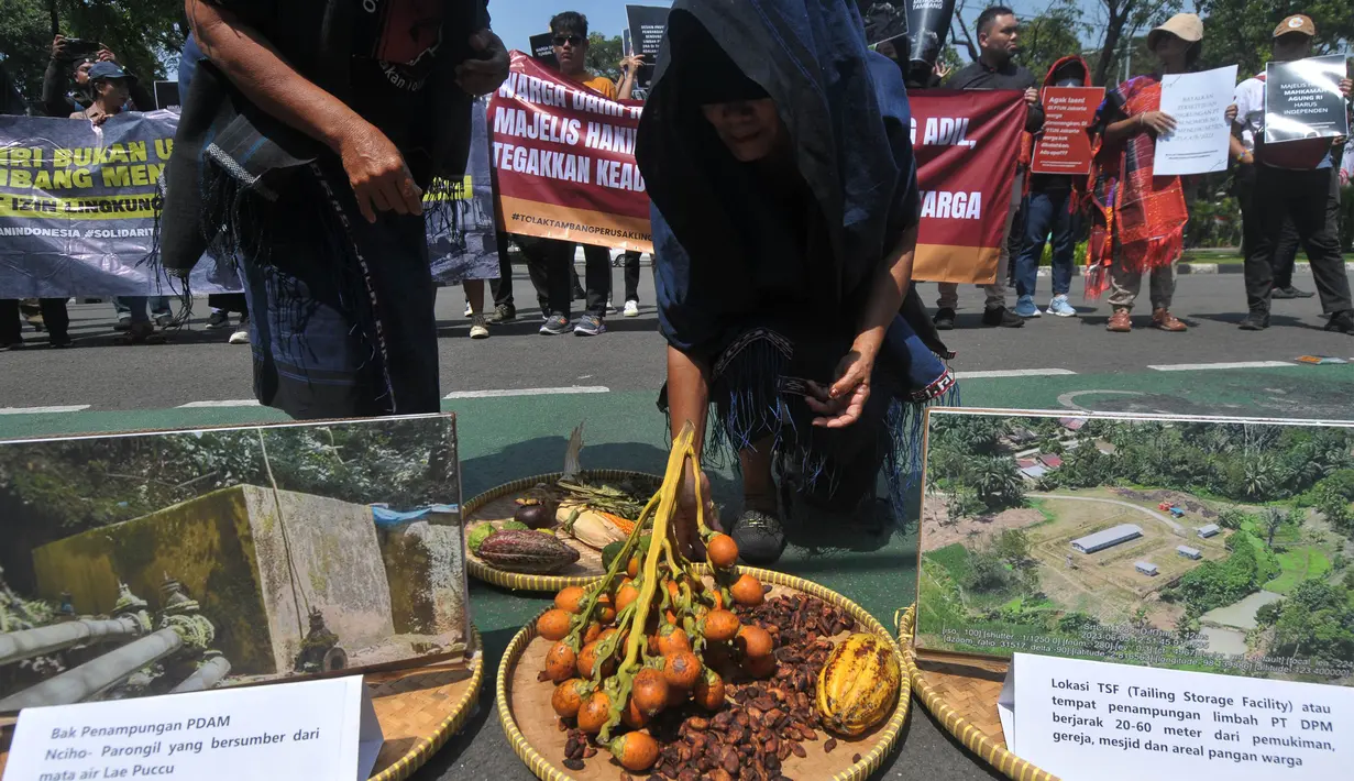 Warga Kabupaten Dairi melakukan aksi teatrikal saat berunjuk rasa di depan Gedung Mahkamah Agung, Jakarta, Selasa (6/8/2024). (merdeka.com/Imam Buhori)