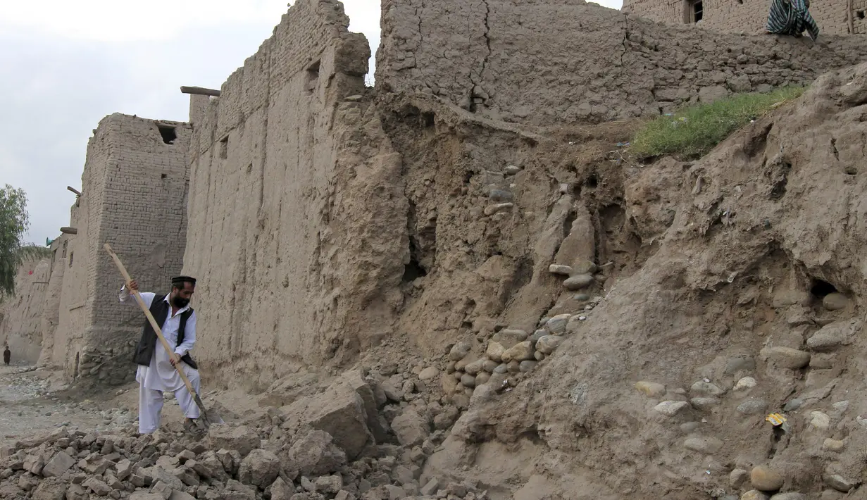 Seorang lelaki membersihkan puing bangunan yang runtuh akibat gempa di Jalalabad, Afghanistan, Senin (26/10/2015). Sekitar 43 orang dipastikan tewas akibat lindu berkekuatan 7,5 skala Richter tersebut. (REUTERS/Parwiz)