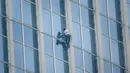Urban climber Alain Robert beraksi memanjat Menara Lotte World di Seoul, Korea Selatan (6/6). Alain Robert memang terkenal karena hobinya memanjat bangunan tinggi, ia juga diberi gelar "French Spiderman". (AFP/Ed Jones)