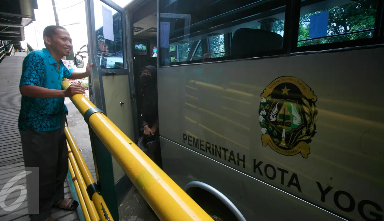 Petugas saat akan menutup pintu bus shelter yang melintasi Jl. Malioboro, Yogyakarta, Selasa (5/4). Bus digunakan untuk mengangkut pejalan kaki yang memarkir kendaraan di Taman Parkir Abu Bakar Ali.  (Liputan6.com/Boy Harjanto)