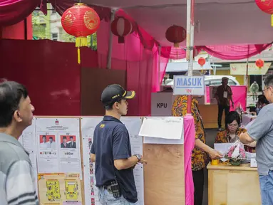 Warga mendaftar saat akan mencoblos di TPS 08 Petak Sembilan, Glodok, Jakarta, Rabu (17/4). TPS 08 Petak Sembilan mengambil tema budaya Tionghoa untuk menarik minat pemilih dan menekan angka golput. (Liputan6.com/Faizal Fanani)