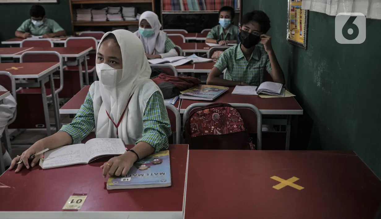 Tanda X dipasang pada setiap meja sebagai pembatas antara tempat duduk siswa di SDN Pekayon Jaya VI, Bekasi, Rabu (24/3/2021). Jam pembelajaran tatap muka di Bekasi juga dibatasi, yakni mulai pukul 08.00 WIB hingga 11.00 WIB. (merdeka.com/Iqbal S. Nugroho)
