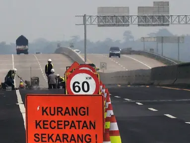 Petugas memperbaiki Jalan Tol Trans Jawa ruas Semarang-Brebes jelang arus mudik 2019 di Kabupaten Brebes, Jawa Tengah, Senin (27/5/2019). Perbaikan terus dilakukan jelang arus mudik 2019. (Liputan6.com/Gholib)