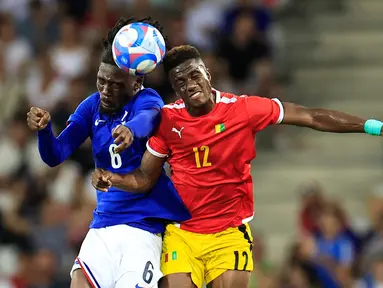 Gelandang Prancis #06 Manu Kone (Kiri) berebut bola dengan penyerang Guinea #12 Algassime Bah pada matchday 2 Grup A sepak bola Olimpiade Paris 2024 di stadion Allianz Riviera, Minggu (28/7/2024). (Valery HACHE / AFP)