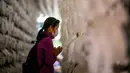 <p>Seorang wanita berdoa di depan lentera teratai putih dengan nama dan doa tertulis pada atasnya setelah kebaktian untuk merayakan ulang tahun Buddha di Kuil Jogye, Seoul, Korea Selatan, Minggu (8/5/2022). (ANTHONY WALLACE/AFP)</p>