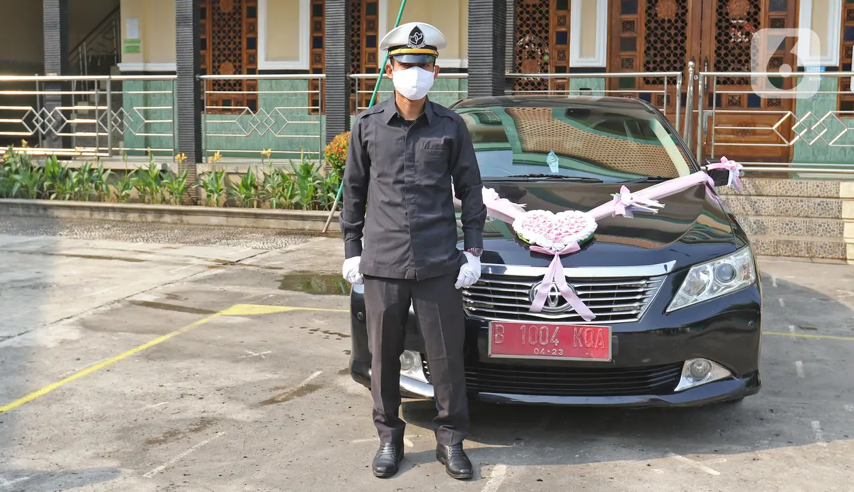 Petugas Muhamad Kholiq berpose seusai mengantarkan pengantin di kawasan Bekasi, Jawa Barat, Sabtu (12/9/2020). Wakil Wali Kota Bekasi menyediakan fasilitas gratis mobil dinas pada hari Sabtu dan Minggu untuk antar jemput pengantin saat pandemi COVID-19. (Liputan6.com/Herman Zakharia)