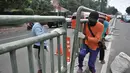 Pekerja dari Dinas Perhubungan DKI Jakarta melakukan pemasangan pagar pembatas jalan di Jalan HOS. Cokroaminoto, Jakarta, Selasa (6/11). Pemasangan pagar bertujuan mencegah pejalan kaki menyeberang sembarangan. (Merdeka.com/ Iqbal S. Nugroho)