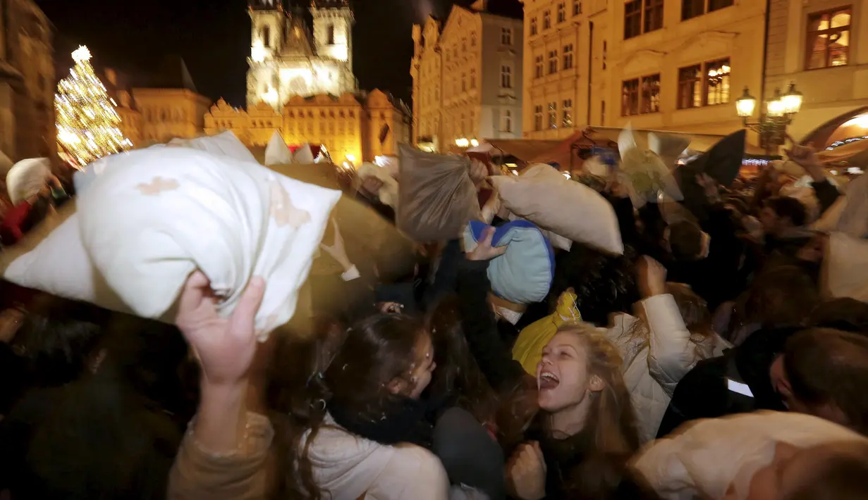 Sejumlah warga saat megambil bagian dalam flash mob perang bantal selama empat menit di Old Town Square di Praha,Ceko (22/12). flash mob perang bantal ini dilakukan jelang pergantian akhir tahun. (REUTERS/ David W Cerny)