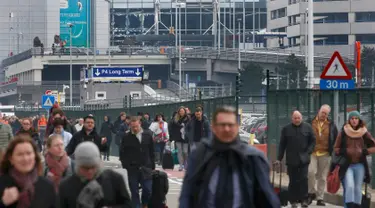 Sejumlah orang berjalan meninggalkan lokasi ledakan di bandara Zaventem dekat Brussels, Belgia, (22/3).Selain terjadi ledakan di Bandara, ledakan juga menghancurkan stasiun metro Maalbeek Brussels. (REUTERS / Francois Lenoir)