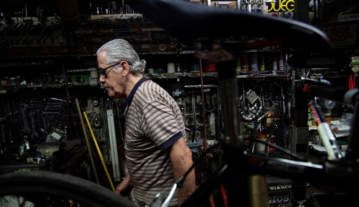 Raffaello Bianco, mekanik dan pecinta sepeda bekerja di bengkel mekaniknya di ruang bawah tanah apartemennya di Turin, Italia, 7 Juli 2020. Pada tahun 1985 Raffaello Bianco memutuskan untuk mendirikan sebuah garasi kecil dekat rumahnya di Turin dan membangunnya perlahan-lahan. (MARCO BERTORELLO/AFP)
