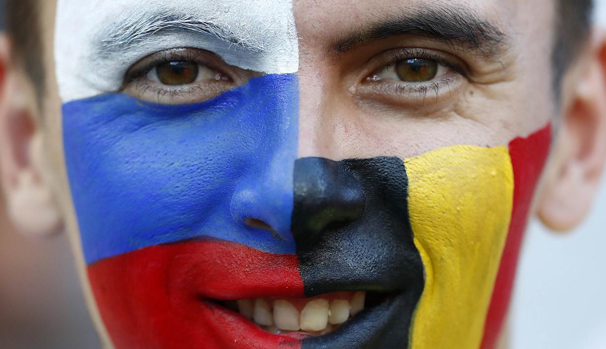 Seorang suporter mengecat mukanya dengan warna bendera Panama dan Belgia pada laga Piala Dunia 2018 di Stadion Fisht, Senin (18/6/2018). Belgia menang 3-0 atas Panama. (AP/Matthias Schrader)