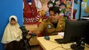 Petugas Disdukcapil Kota Tangerang Selatan melakukan pembuatan Kartu Identitas Anak (KIA) di tempat makan siap saji kawasan Bintaro Tangerang Selatan, Selasa (26/2). (Merdeka.com/Arie Basuki)
