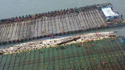 Bangkai kapal feri Sewol yang tenggelam hampir tiga tahun lalu dan menewaskan 304 orang, muncul ke permukaan, di pulau barat daya Jindo, Korea Selatan, Kamis (23/3). Upaya pengangkatan telah berlangsung sejak Rabu kemarin. (Park Gyung-woo/Hankookilbo/AP)