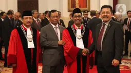 Menkopolhukam Mohamad Mahfud MD berfoto bersama Hakim Mahkamah Konstitusi (MK),  Suhartoyo dan Daniel Yusmic Pancastaki seusai pelantikan di Istana Negara, Jakarta, Selasa (7/1/2020). Keduanya akan bertugas dengan masa jabatan lima tahun ke depan. (Liputan6.com/Angga Yuniar)