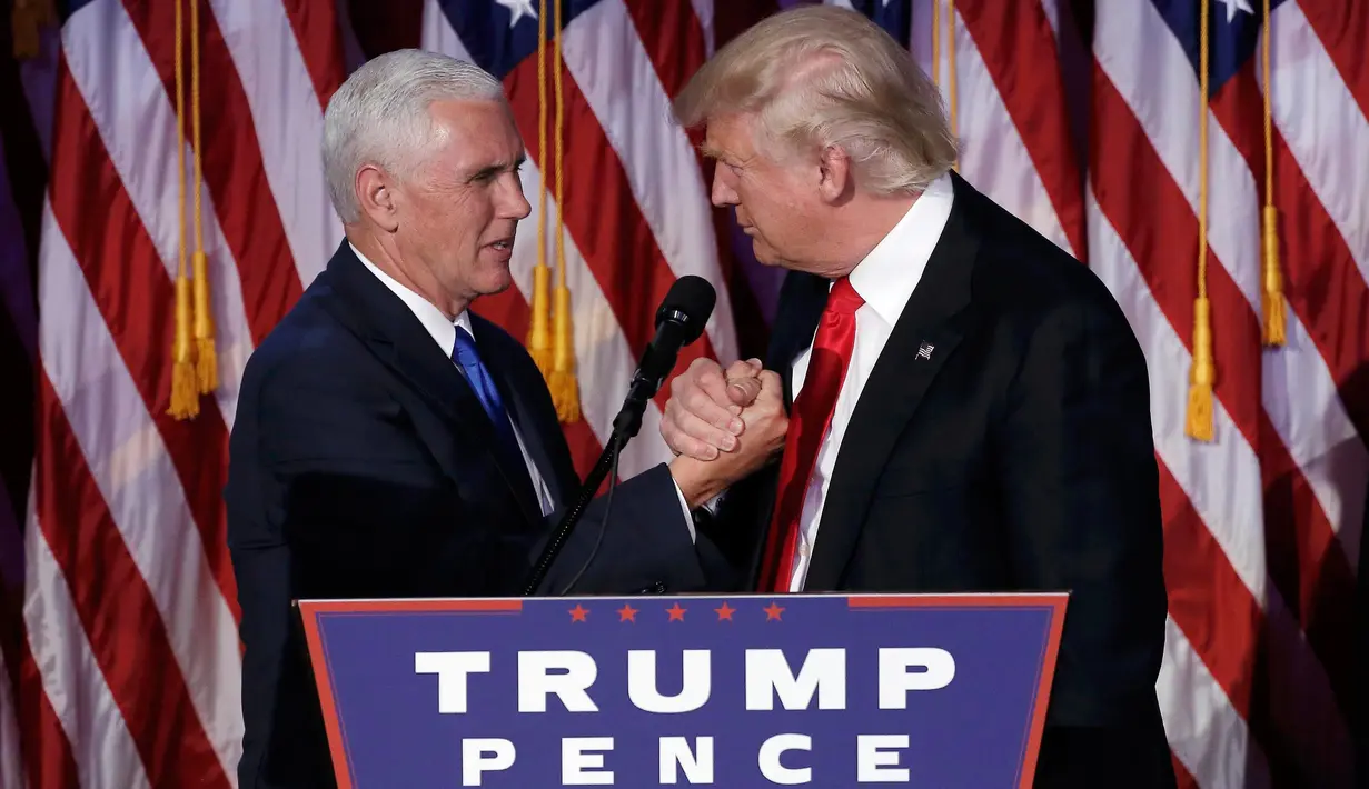 Presiden ke-45 AS Donald Trump dan Wakil Presiden Mike Pence berjabat tangan di hadapan pendukung di Manhattan, New York, Rabu (9/11). Trump berhasil mendapat suara electoral votest lebih dari 270 sebagai syarat kemenangan Pilpres AS. (REUTERS/Mike Segar)