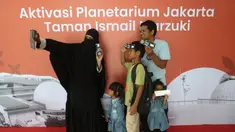 Pengunjung berswafoto sebelum memasuki area Planetarium di Taman Ismail Marzuki, Jakarta, Kamis (25/12/2025). Planetarium Taman Ismail Marzuki (TIM) akhirnya dibuka kembali. Planetarium Taman Ismail Marzuki (TIM) akhirnya dibuka kembali. (Kapanlagi.com/Budy Santoso)